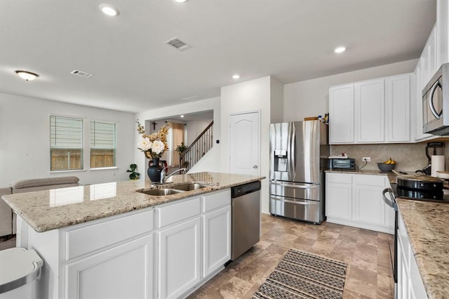 kitchen featuring tasteful backsplash, visible vents, stainless steel appliances, and a sink