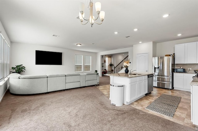 kitchen with light stone counters, recessed lighting, light carpet, white cabinets, and appliances with stainless steel finishes