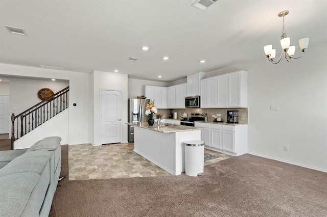 kitchen featuring light colored carpet, visible vents, appliances with stainless steel finishes, open floor plan, and white cabinetry