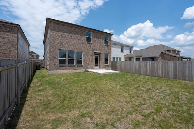 rear view of house featuring brick siding, a lawn, a patio area, and a fenced backyard