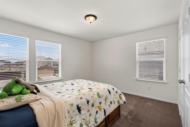 bedroom with dark colored carpet and a closet