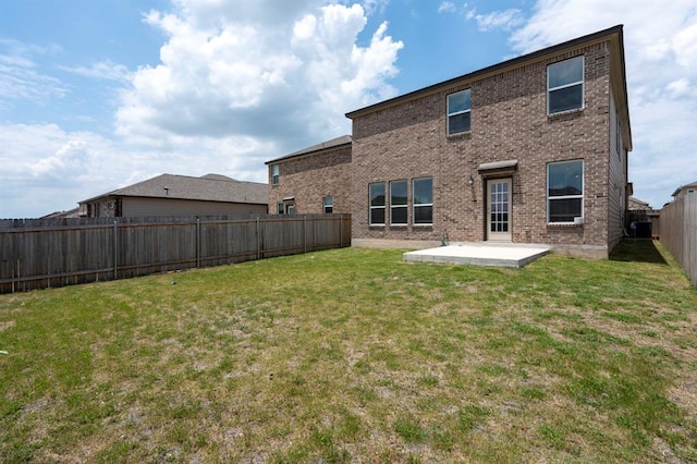 back of property with a patio area, brick siding, a lawn, and a fenced backyard