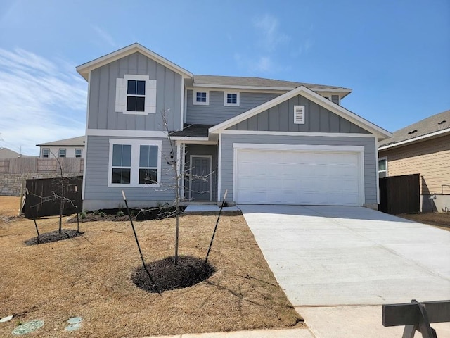 view of front of property with driveway, board and batten siding, an attached garage, and fence