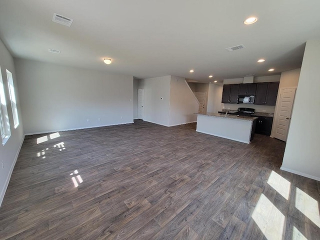 unfurnished living room with stairway, visible vents, and dark wood-type flooring