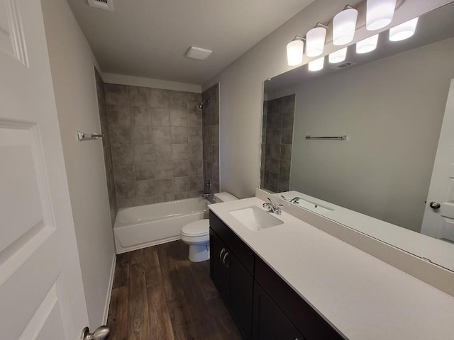 full bathroom with shower / washtub combination, visible vents, toilet, vanity, and wood finished floors