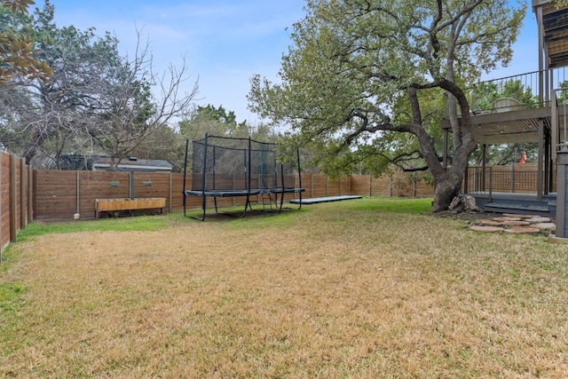 view of yard featuring a trampoline and a fenced backyard