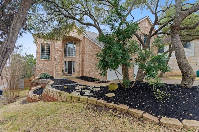 view of front of property featuring a garage and brick siding