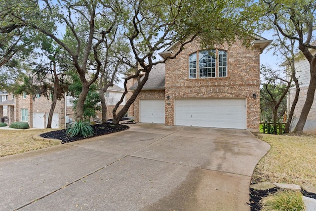 traditional home with concrete driveway, brick siding, and an attached garage