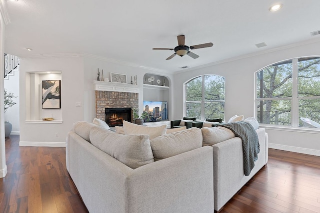 living room featuring dark wood-style floors, a healthy amount of sunlight, and ornamental molding