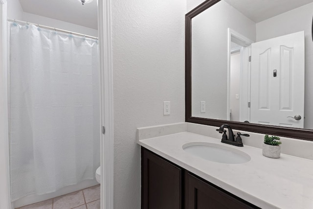 bathroom featuring toilet, curtained shower, vanity, and tile patterned floors