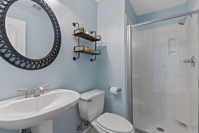 full bath featuring visible vents, a textured wall, toilet, a shower stall, and a sink