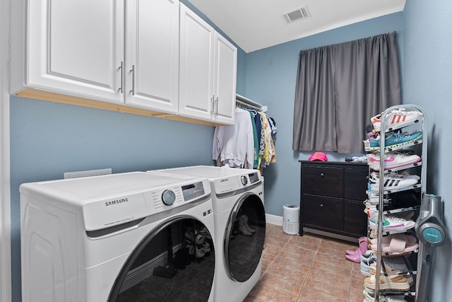 clothes washing area with light tile patterned floors, cabinet space, visible vents, washer and dryer, and baseboards