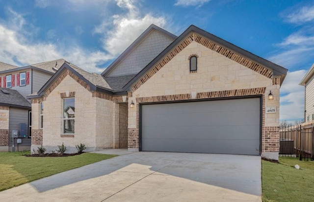 french country home featuring concrete driveway, brick siding, a front lawn, and an attached garage