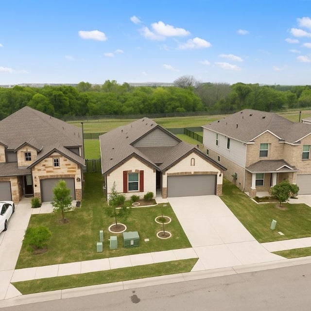 4805 Cressal Dr, Pflugerville, TX 78653 - view of front of house with a garage, driveway, a front lawn, stone siding, and a residential view