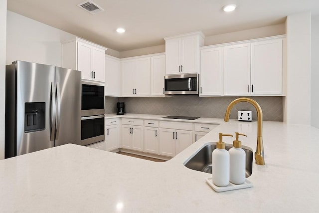 4805 Cressal Dr, Pflugerville, TX 78653 - kitchen with stainless steel appliances, white cabinets, light countertops, decorative backsplash, and recessed lighting