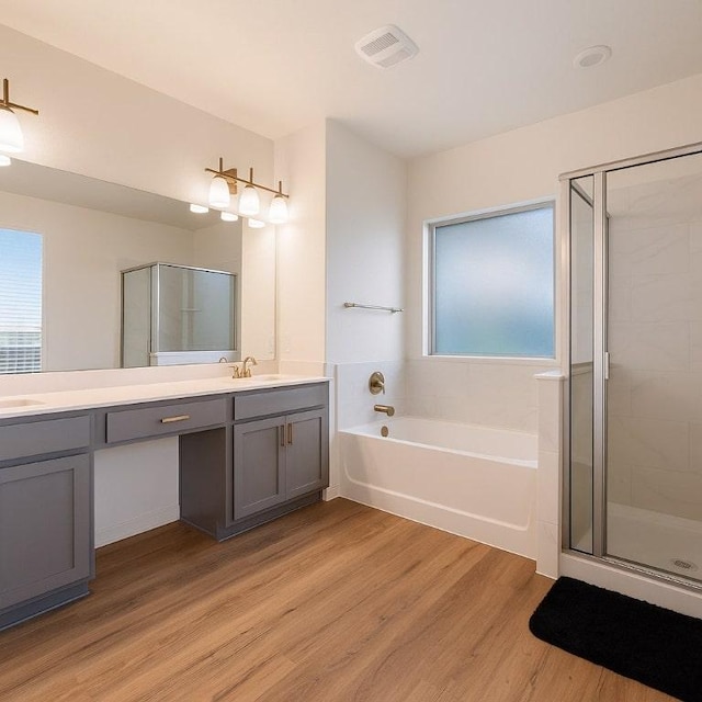 4805 Cressal Dr, Pflugerville, TX 78653 - full bath featuring wood finished floors, double vanity, a bath, and plenty of natural light