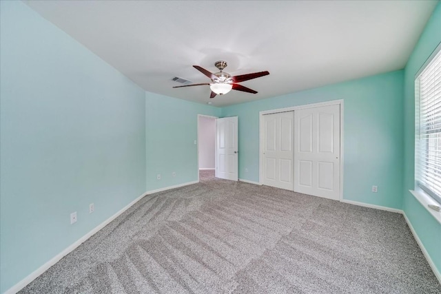 unfurnished bedroom with ceiling fan, carpet floors, visible vents, baseboards, and a closet