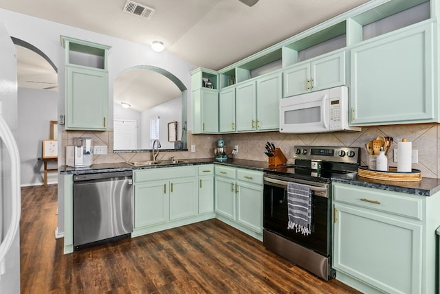 kitchen with open shelves, stainless steel appliances, visible vents, a sink, and green cabinetry