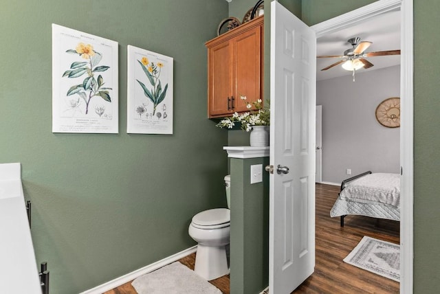 bathroom with a ceiling fan, toilet, baseboards, and wood finished floors