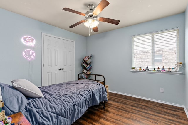 bedroom featuring a ceiling fan, a closet, baseboards, and wood finished floors