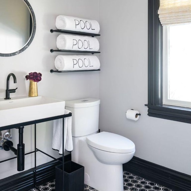 bathroom featuring baseboards and toilet