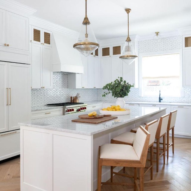 kitchen featuring custom range hood, a kitchen island, range, and crown molding