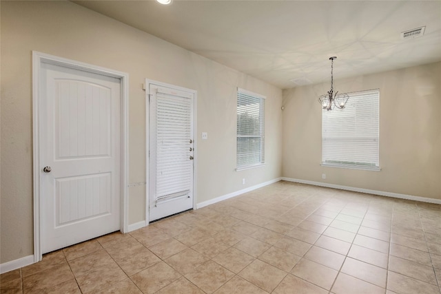 interior space featuring light tile patterned floors, baseboards, visible vents, and a chandelier