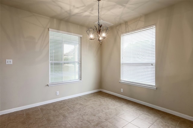 spare room featuring an inviting chandelier, light tile patterned floors, and baseboards