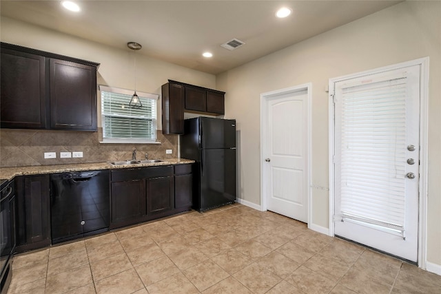 kitchen with light stone counters, visible vents, a sink, black appliances, and tasteful backsplash