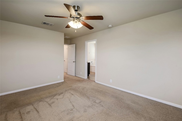 spare room featuring visible vents, carpet floors, baseboards, and a ceiling fan