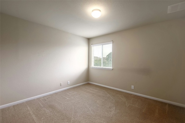 spare room with visible vents, light carpet, and baseboards