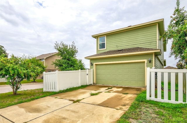 view of front of house with a garage and fence