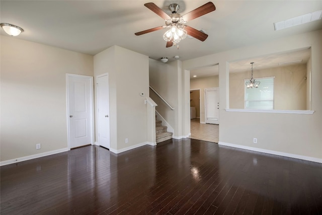 unfurnished room with stairway, ceiling fan with notable chandelier, baseboards, and wood finished floors