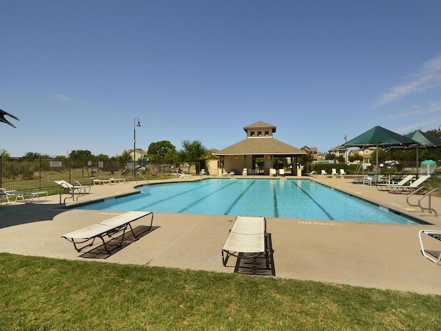 community pool with a gazebo, a patio area, and fence