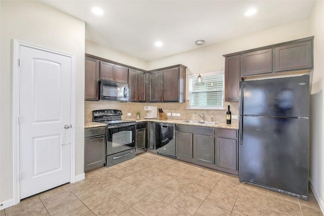 kitchen featuring backsplash, dark brown cabinets, black appliances, and a sink