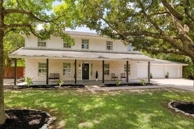 view of front of home featuring a garage, a porch, concrete driveway, and a front yard