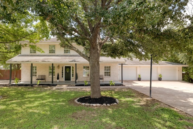 view of front of house featuring driveway, an attached garage, a front lawn, and a porch