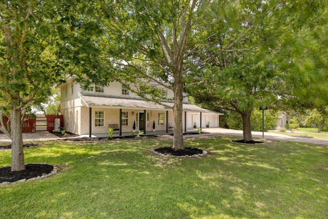 view of front facade featuring driveway, a porch, fence, and a front lawn