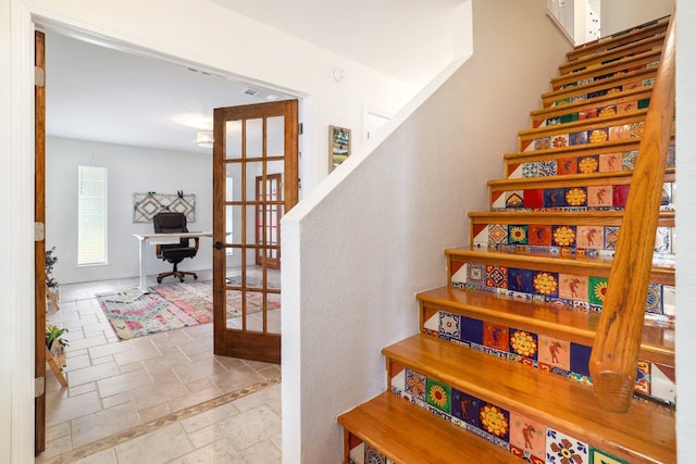 stairs with stone tile flooring, visible vents, and french doors