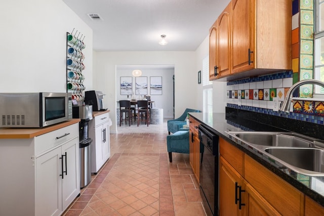 kitchen featuring a sink, plenty of natural light, stainless steel microwave, and dishwasher