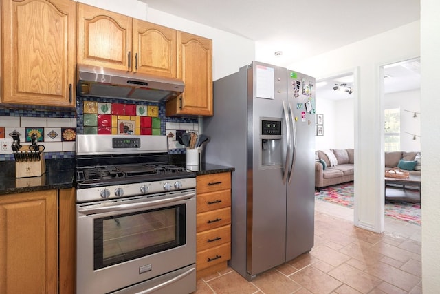 kitchen with under cabinet range hood, tasteful backsplash, appliances with stainless steel finishes, and dark stone countertops