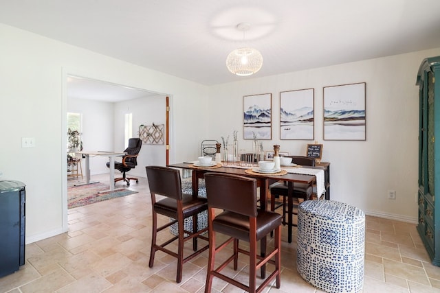 dining space featuring stone finish floor and baseboards