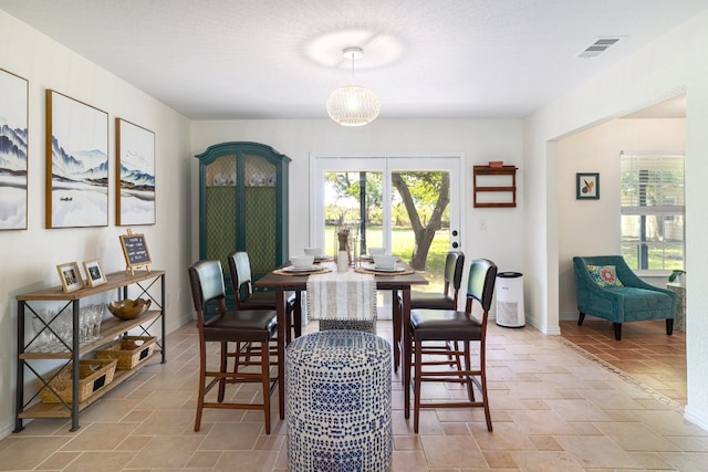 dining room with stone finish flooring, visible vents, and baseboards