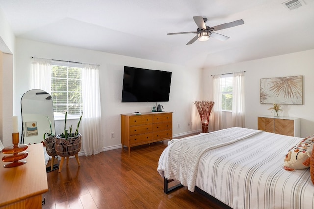 bedroom featuring lofted ceiling, hardwood / wood-style flooring, a ceiling fan, visible vents, and baseboards