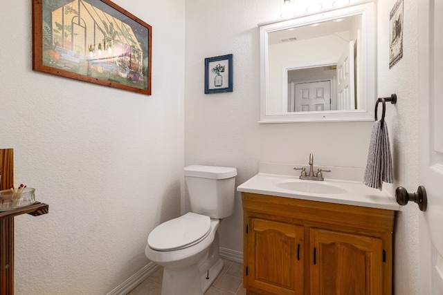 half bathroom featuring vanity, toilet, and tile patterned floors