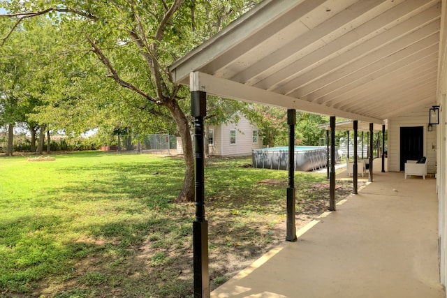 view of yard featuring a patio area, an outdoor pool, and fence