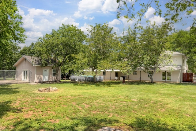 view of yard featuring a fire pit, a covered pool, and fence