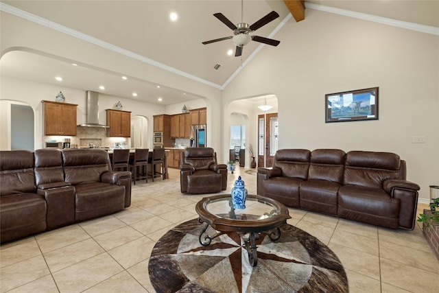 living area with high vaulted ceiling, arched walkways, crown molding, and light tile patterned floors