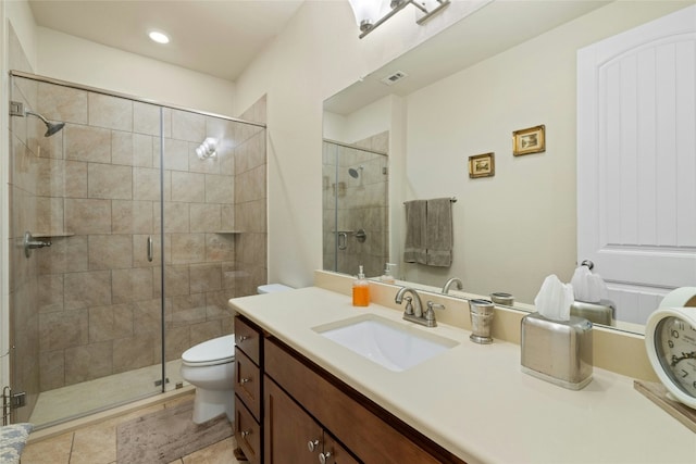 bathroom with tile patterned flooring, toilet, vanity, visible vents, and a stall shower