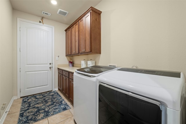 laundry room featuring cabinet space, visible vents, washing machine and clothes dryer, and light tile patterned floors